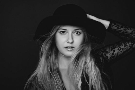 Beautiful blonde woman wearing a hat, artistic film portrait in black and white for fashion campaign and beauty brands