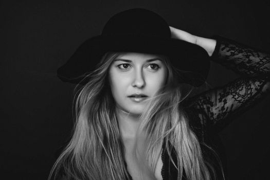 Beautiful blonde woman wearing a hat, artistic film portrait in black and white for fashion campaign and beauty brands