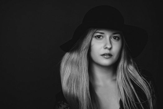 Beautiful blonde woman wearing a hat, artistic film portrait in black and white for fashion campaign and beauty brands