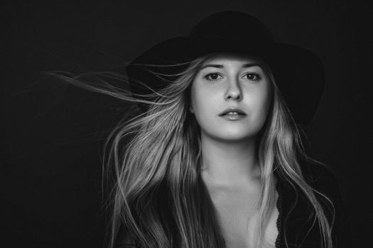 Beautiful blonde woman wearing a hat, artistic film portrait in black and white for fashion campaign and beauty brands