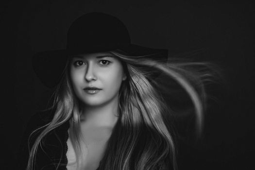 Beautiful blonde woman wearing a hat, artistic film portrait in black and white for fashion campaign and beauty brands