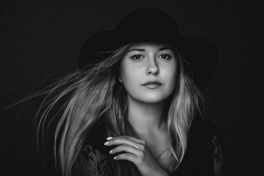 Beautiful blonde woman wearing a hat, artistic film portrait in black and white for fashion campaign and beauty brands