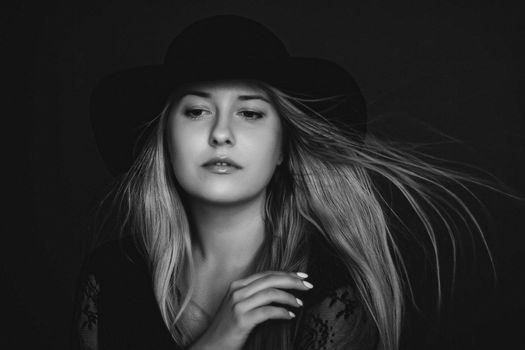 Beautiful blonde woman wearing a hat, artistic film portrait in black and white for fashion campaign and beauty brands