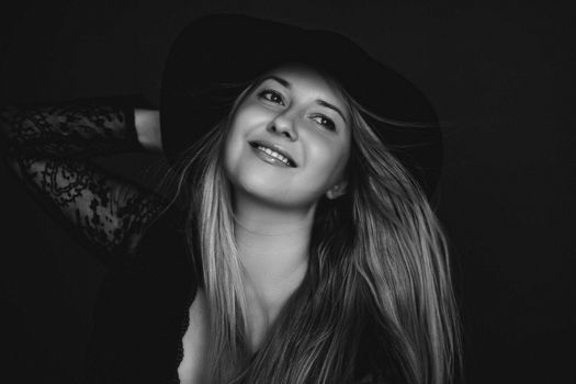 Beautiful blonde woman wearing a hat, artistic film portrait in black and white for fashion campaign and beauty brands