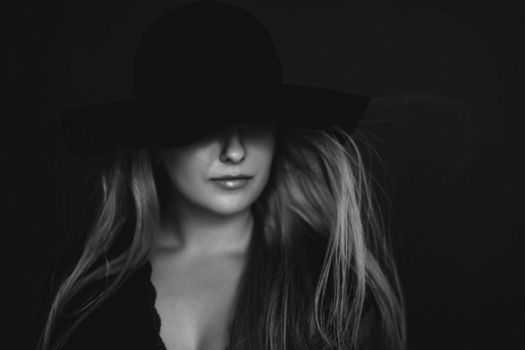 Beautiful blonde woman wearing a hat, artistic film portrait in black and white for fashion campaign and beauty brands