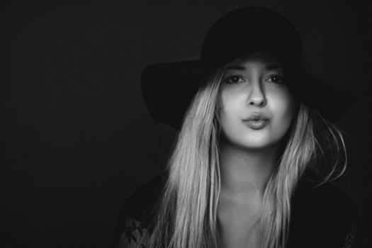 Beautiful blonde woman wearing a hat, artistic film portrait in black and white for fashion campaign and beauty brands