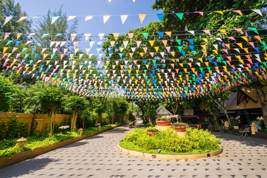 Multi colored triangular Flags Hanging in the sky on outdoor road at celebration party