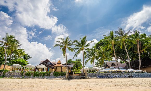 Tropical beach resort with lounge chairs and umbrellas