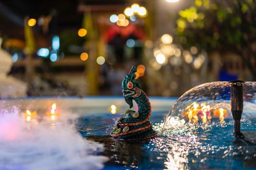 Naga statue in the water at night