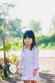 little girl in nightdress get up in the morning and standing with hold flower bouquet in her hand