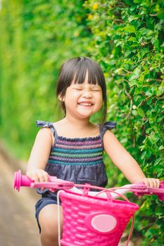 happy little girl ride a bicycle in the park