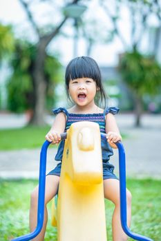 Asian little girl enjoys playing in a children playground