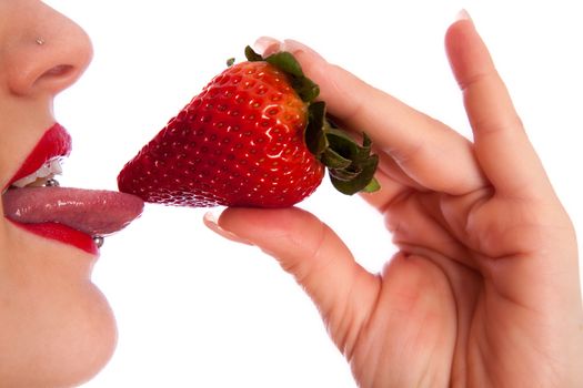 Young woman with a strawberry over mouth