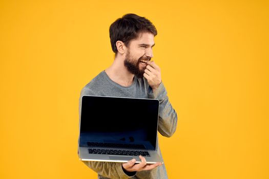 man with laptop wireless technology internet lifestyle work yellow isolated background. High quality photo