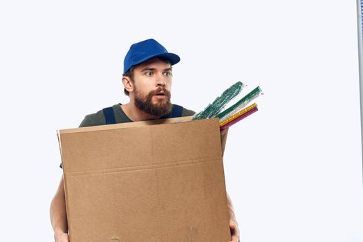 A man in a working uniform with a box in his hands delivery transportation work. High quality photo