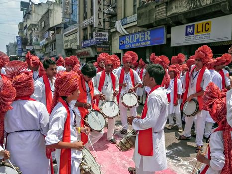 Pune,Maharashtra,India-September 22nd,2010:Group of youths beating traditional tasha collectively during festival procession of ganesh as people in crowd watch.