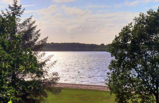 Beautiful sunny landscape at a lake with a reflective water surface.