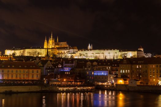 Beautiful night view of the light illuminated Prague Castle and St. Vitus Cathedral in Mala Strana old town by Vltava River from Charles Bridge, Prague, Czech Republic