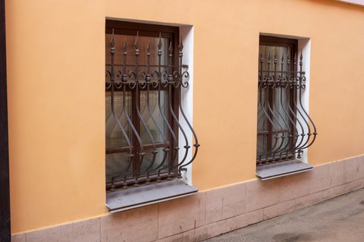 Facade on the side. Windows with iron bars with the ligature.