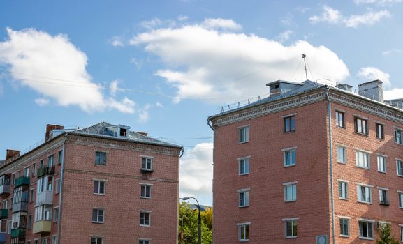 Two pink apartment buildings against the sky.