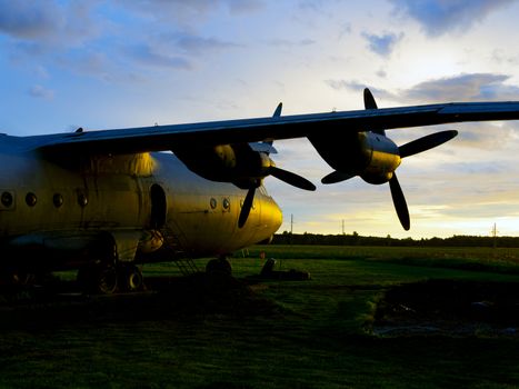 old Soviet military airplane, sunset time. Abandoned Historic Aircraft in Estonia AN-12. Close up of propeller engine. Copy space