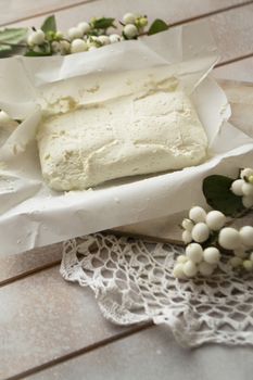 white homemade cheese - traditional milk creamy dairy product on vintage wooden board. Rustic style. Vertical image