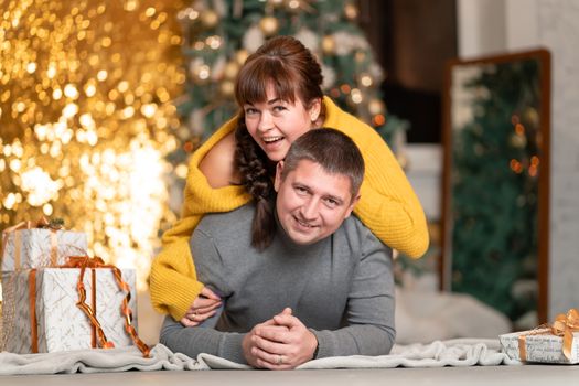 A beautiful cheerful couple greets the Christmas holidays in a cozy home atmosphere.