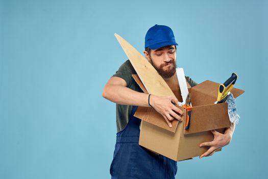 Worker man in uniform box tools construction blue background. High quality photo