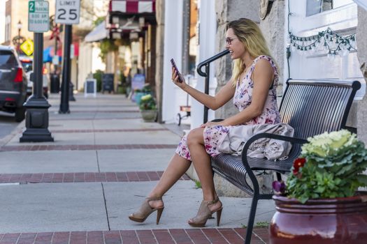 A gorgeous blonde model enjoys a summers day outdoors in a small town
