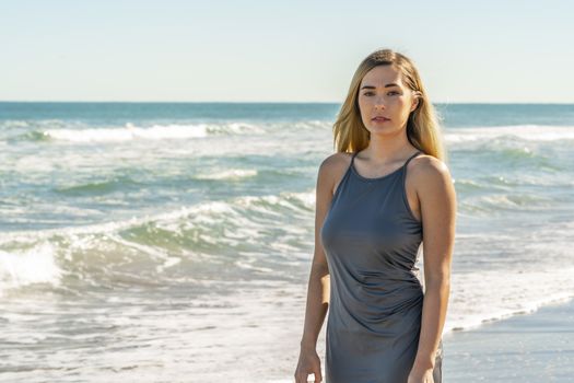 A gorgeous young blonde female enjoys a day at the beach alone