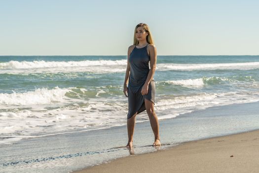 A gorgeous young blonde female enjoys a day at the beach alone