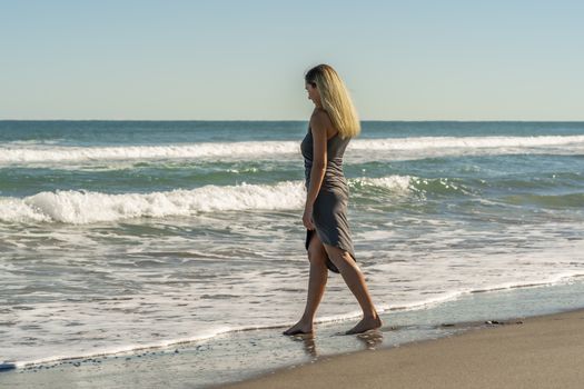 A gorgeous young blonde female enjoys a day at the beach alone