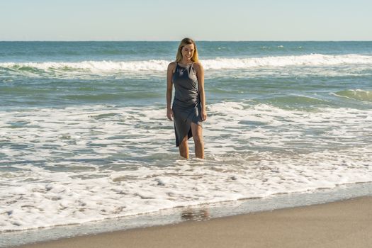 A gorgeous young blonde female enjoys a day at the beach alone