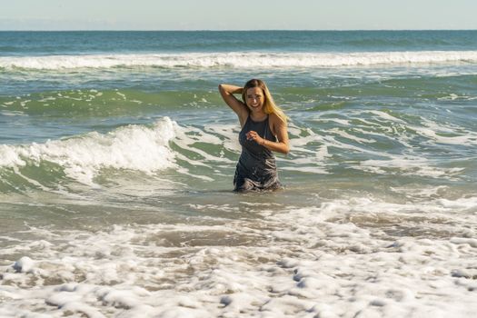A gorgeous young blonde female enjoys a day at the beach alone