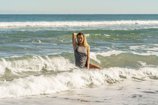 A gorgeous young blonde female enjoys a day at the beach alone