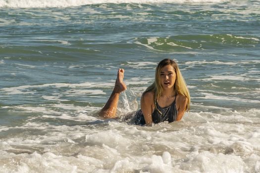 A gorgeous young blonde female enjoys a day at the beach alone
