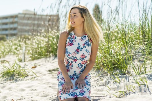 A gorgeous young blonde female enjoys a day at the beach alone