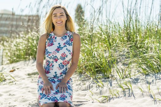 A gorgeous young blonde female enjoys a day at the beach alone