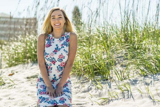A gorgeous young blonde female enjoys a day at the beach alone