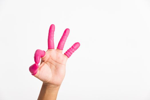 Woman hand wearing pink finger cots rubber protect help prevent fingerprints on the finger touched piece with OK sign gesturing, studio shot isolated on white background