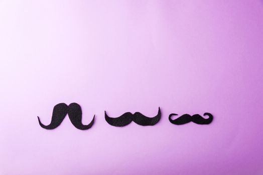 Black mustache paper, studio shot isolated on purple background, Prostate cancer awareness month, Fathers day, minimal November moustache concept