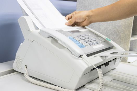 hand man are using a fax machine in the office, equipment for data transmission.