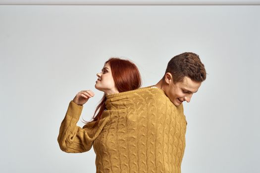 couple in yellow sweater posing against light background cropped view. High quality photo