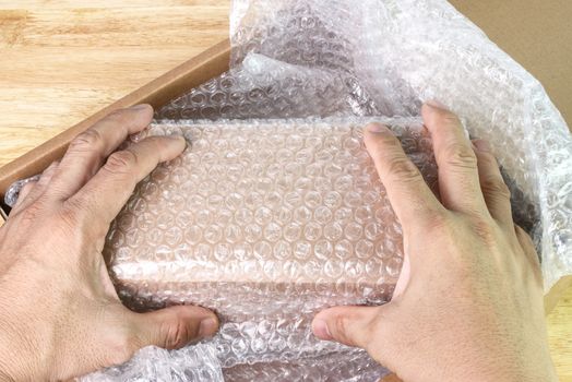 hand of man hold bubble wrap, for protection parcel product cracked or insurance During transit  