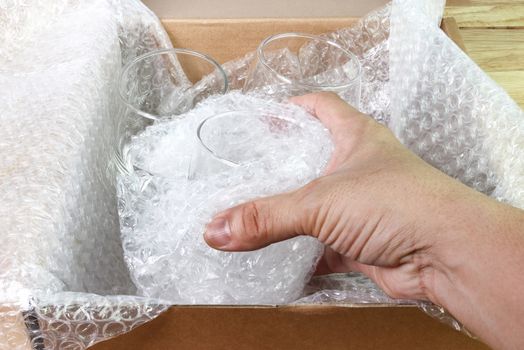 hand of man hold bubble wrap cover glass for protection product cracked or insurance During transit  