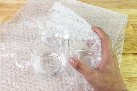 hand of man hold bubble wrap cover glass for protection product cracked or insurance During transit  