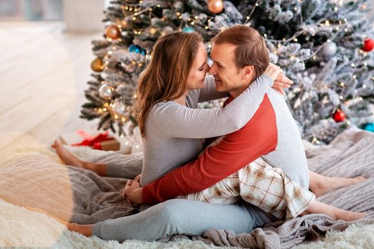 Happy couple having fun near Chrismas tree at home