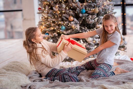 Happy kids having fun and opening presents near christmas tree.