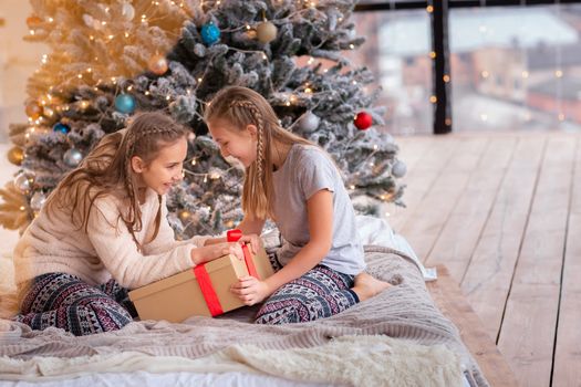 Happy kids having fun and opening presents near christmas tree.