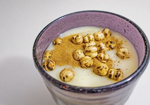 traditional turkish drink boza in glass with cinnamon powder and roasted chickpeas